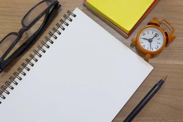 Блокнот с желтой запиской, учебные очки, ручка и будильник. Плоский лежал — стоковое фото
