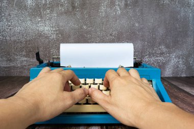 Eski klasik mavi daktilodaki adam ahşap masada. İş konsepti. Boşluğu kopyala.