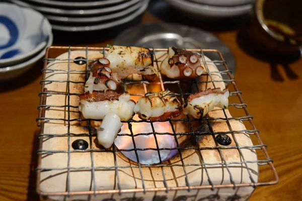 炭火ストーブで焼きタコの選択的な焦点 食と旅のコンセプト — ストック写真