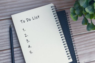 Not defterine, kaleme ve saksı bitkisine metin yazmak için tahta masaya.