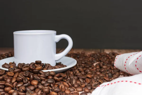 Cup of coffee on coffee beans and blurred background. Food and beverage concept.