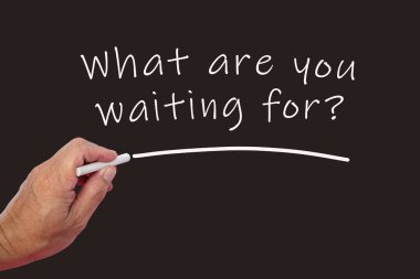 Male hand writes in white chalk pencil the word What Are You Waiting For with question mark on a black background. Encouragement phrases and business concept.