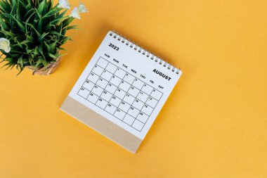 August 2023 desk calendar on yellow background. Directly above. Flat lay. Copy space.