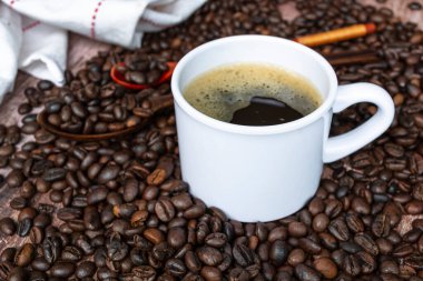 Cup of coffee on coffee beans and blurred background. Food and beverage concept. Copy space.