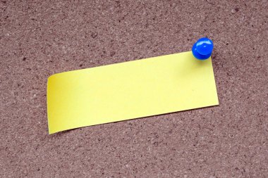 Sarı not ve mantar uyarı panosuna iğnelenmiş. Uzayı kopyala Hatırlatma konsepti.