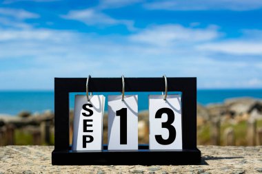 Sep 13 calendar date text on wooden frame with blurred background of ocean. Calendar date concept.