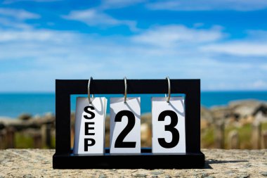 Sep 23 calendar date text on wooden frame with blurred background of ocean. Calendar date concept.