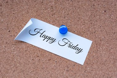 Happy Friday word on white stick note and pinned to a cork notice board.
