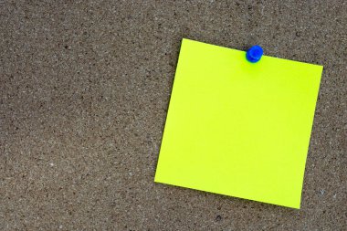 Sarı not ve mantar uyarı panosuna iğnelenmiş. Uzayı kopyala Hatırlatma konsepti.