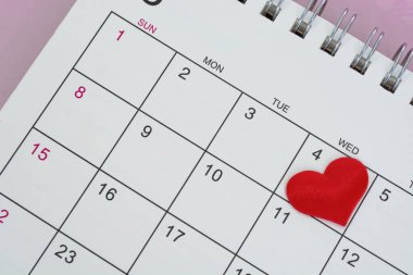 Red heart shape on the date of the 4th day in the calendar. Important calendar date to remember.