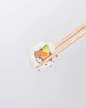 Çubuklar somon ve avokado suşisi topluyor.