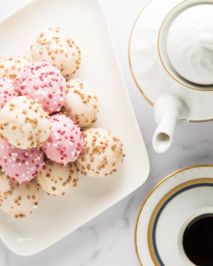 Kahve masasında beyaz ve pembe çikolata kaplı çörek.