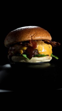 Burger with lettuce, bacon, cheese and onion.