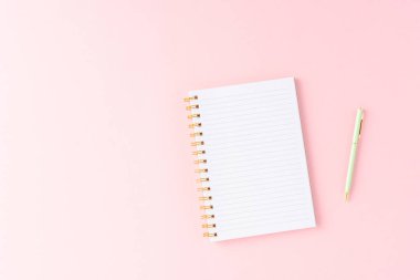 Pembe arka planda bir defter. Üst görünüm