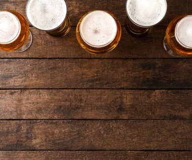 Kopyalama alanı olan ahşap masada bira bardakları.