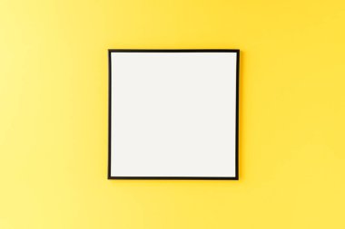 Kopyalama alanı ile sarı arkaplan üzerindeki boş resim çerçevesinin maketi
