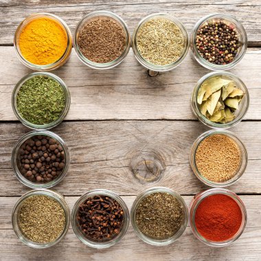 Kâselerdeki çeşitli çeşitler. Kopyalama alanı ile ahşap arkaplan üzerindeki baharat koleksiyonu