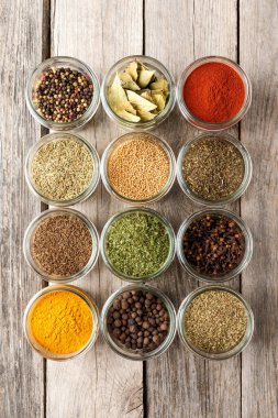 Kâselerdeki çeşitli çeşitler. Ahşap arka planda baharat koleksiyonu