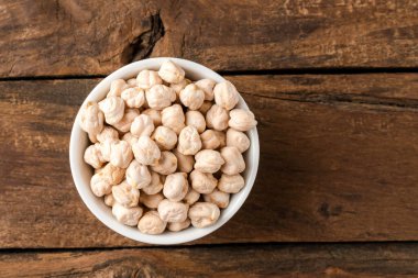 Kırsal ahşap masada nohut çekirdeği kasesinde. Üst görünüm