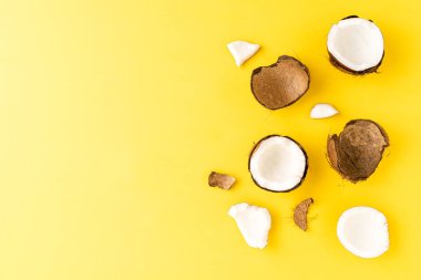 Sarı arkaplandaki hindistan cevizi parçalarının fotokopi çekimleri. Düz yatıyordu