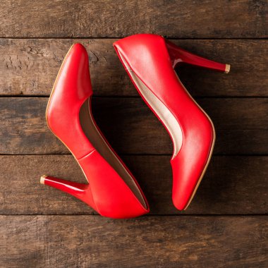 Ahşap arka planda kırmızı yüksek topuklu bir atış. Üst görünüm