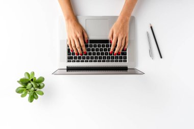 Kadın elleri aksesuarlarla birlikte beyaz masada dizüstü bilgisayarda çalışıyor. İş geçmişi. Düz yatıyordu