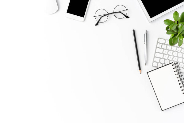 Overhead shot of office desktop with accessories on white table. Business background