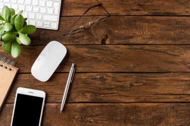 Telif alanı olan ahşap arka planda bilgisayar ve iş aksesuarları bulunan ofis masaüstü