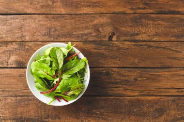 Yeşil salata, ıspanak, roka ve pancar yapraklarını kristal ahşap masa üzerinde, kopyalanmış. Üst görünüm