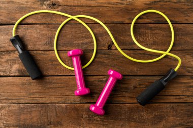 Dambıllar ve atlama halatı eski ahşap zeminde. Spor arkaplanı