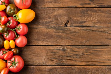 Kırsal ahşap arka planda domates ve kopyalanmış uzayın karışımı. Üst görünüm