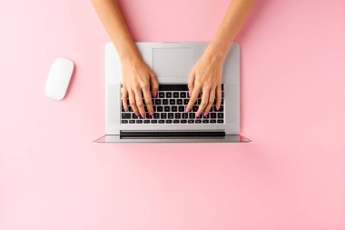 Pembe masada dizüstü bilgisayar kullanan kadınların el resimleri. Ofis masaüstü. Düz yatıyordu