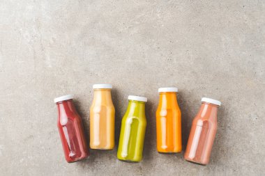 Taze meyve ve sebze püresi şişelerde taş masada, kopyalanmış.