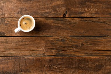 Kahve fincanı, kopyalanmış ahşap masa üzerinde. Üst görünüm