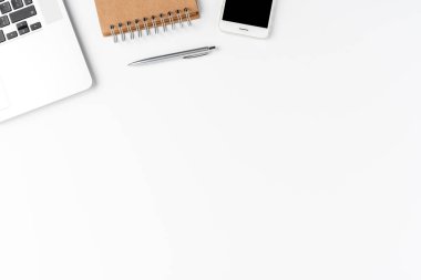 Laptop, cep telefonu, defter ve kalemle mükemmel bir iş geçmişi var. Ofis masaüstü. Üst görünüm