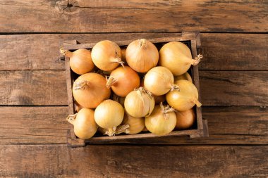 Köy ahşap masadaki sandıkta taze beyaz soğanlar. Üst görünüm