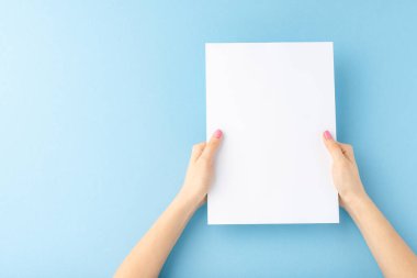 Mavi arka planda boş kağıt kağıtlar gösteren kadın elleri. Kapat. 