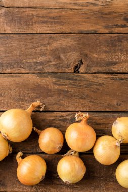 Kopyalanmış ahşap masa üzerinde taze soğan ampulleri. Üst görünüm