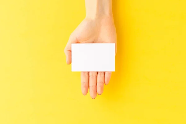 Eine Frau Hält Eine Leere Visitenkarte Auf Gelbem Hintergrund Nahaufnahme — Stockfoto