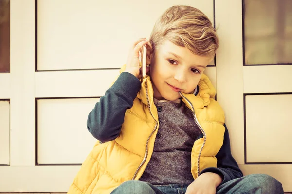 Cute Kid Talking Mobile Phone While Relaxing Outdoors — Zdjęcie stockowe