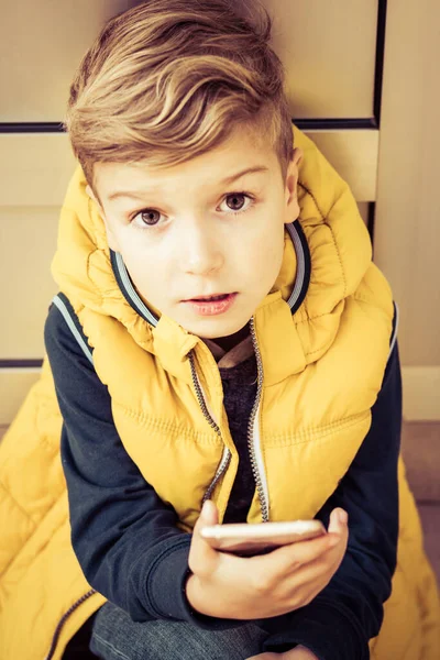 Cute Kid Holding Smart Phone While Looking Camera — Stock fotografie