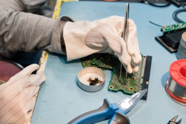 Close up of elementary student repairing computer part for school science project in IT lab. 
