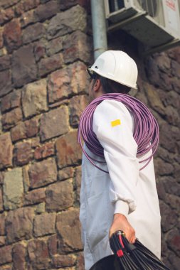Low angle view of construction worker inspecting building exterior. 