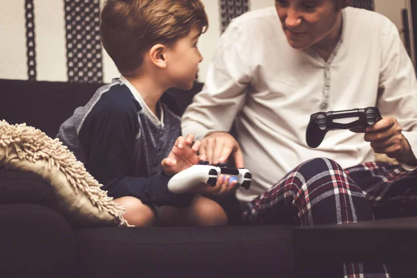 Close up little boy teaching his father how to play games with game controller.