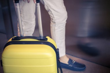 Close0up of man with travel bag by the elevator in a hallway.