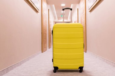 Yellow suitcase in a hallway. Travel bag.