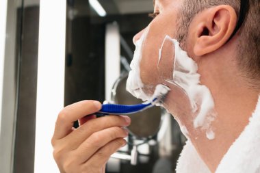 Close-up of man shaving in the morning. 
