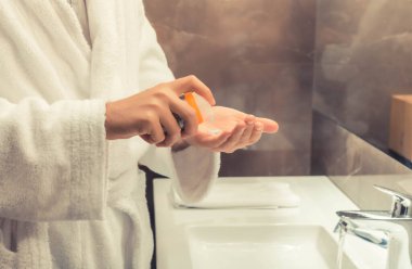 Close-up of man using aftershave in the bathroom. 