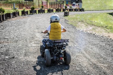 Small boy enjoying while driving quad bike.