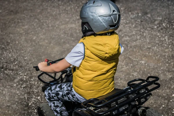Little boy enjoying in off-road ride on atv vehicle.